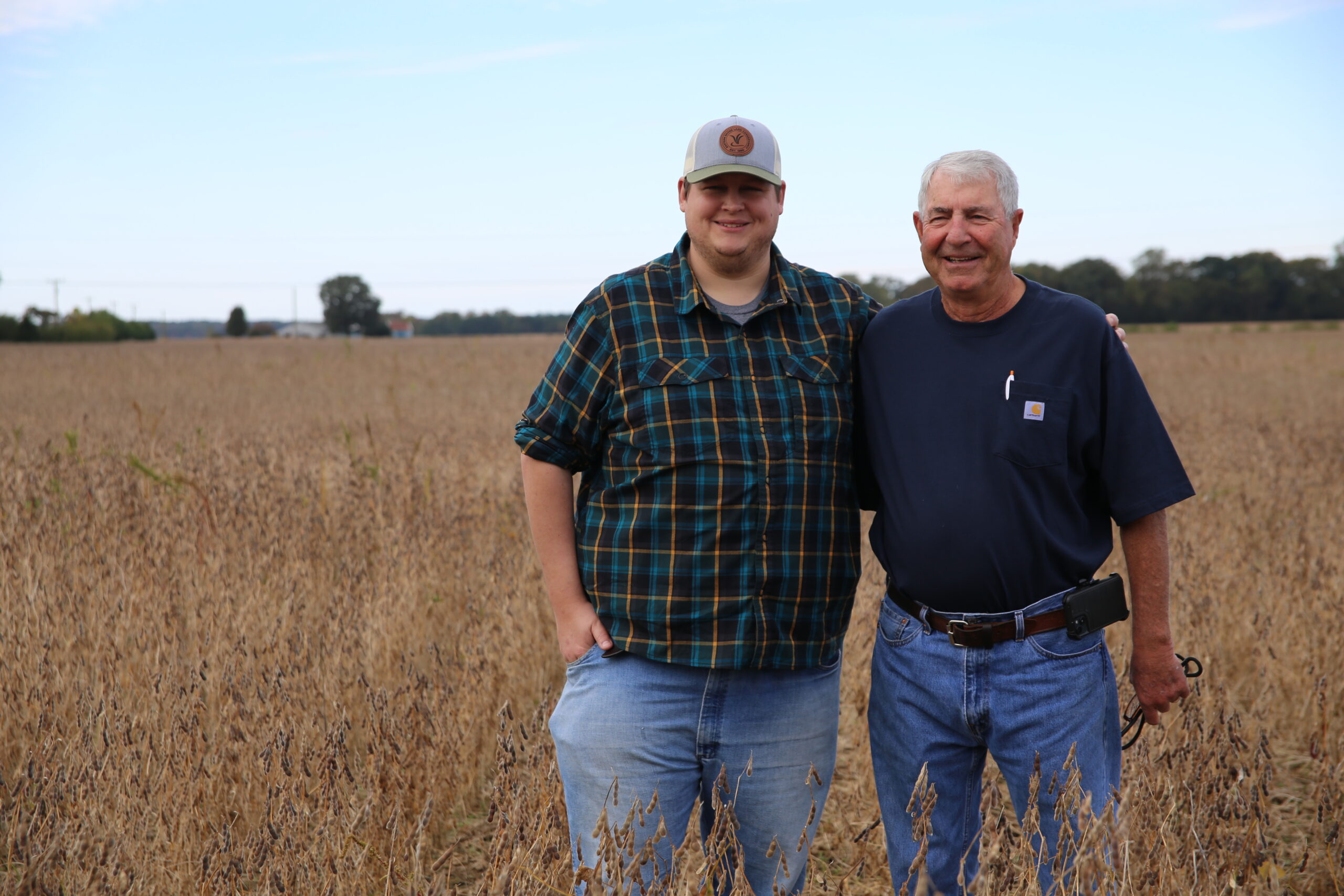 Walt Coulbourne and ESLC's Director of Land Use and Policy David Satterfield stand in a soybean field on their family's Century Farm